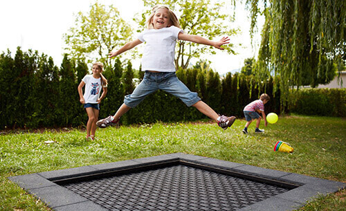girl jumping on playground trampoline
